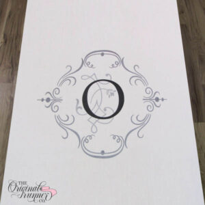 An elegant two-tone frame, featuring a combination of black and silver, creates an understated and sophisticated design. The frame incorporates subtle details to gracefully surround a single initial, making it a perfect choice for your custom wedding aisle runner. "O" Wedding logo.